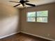 Bright bedroom featuring hardwood floors, a ceiling fan, and a window with tree-filled outdoor views at 1902 W Aileen St, Tampa, FL 33607