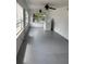 Sun-filled Florida room with gray painted floors, washer, lots of windows, and multiple ceiling fans at 1902 W Aileen St, Tampa, FL 33607