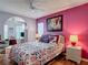 Bright bedroom boasts pink walls, a floral comforter, and stylish decor at 2018 E Del Webb Blvd, Sun City Center, FL 33573