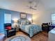 Comfortable bedroom featuring wood floors, ceiling fan, recliner, and colorful decor at 2018 E Del Webb Blvd, Sun City Center, FL 33573