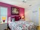 Charming bedroom with a vibrant pink accent wall and cozy décor at 2018 E Del Webb Blvd, Sun City Center, FL 33573