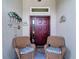 Cozy front porch with two wicker chairs with striped cushions and decorative seaside ornaments at 2018 E Del Webb Blvd, Sun City Center, FL 33573