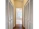 Hallway with wood floors and multiple storage closets leads to ensuite bathroom at 2018 E Del Webb Blvd, Sun City Center, FL 33573