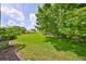 Expansive grassy backyard with mature trees, offering ample space and privacy at 2220 Nantucket Dr # 43, Sun City Center, FL 33573