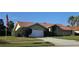 Charming single-story home with a red tile roof, well-maintained landscaping, and an attached two-car garage at 2704 E Montague E Ct, Clearwater, FL 33761