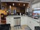 Kitchen featuring stainless steel dishwasher, white cabinets, and backyard view at 2704 E Montague E Ct, Clearwater, FL 33761