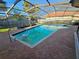Beautiful in-ground pool with brick patio, screened enclosure, and lush green surroundings at 2704 E Montague E Ct, Clearwater, FL 33761
