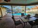 Screened patio with outdoor seating overlooking a private swimming pool surrounded by lush landscaping at 2704 E Montague E Ct, Clearwater, FL 33761