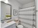 This bathroom features a sleek vanity, framed mirror, and shower with a stylish striped curtain at 28847 Orange Berry Dr, Wesley Chapel, FL 33543
