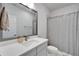 Bathroom featuring a modern sink vanity with gray framed mirror and tub with gray striped shower curtain at 28847 Orange Berry Dr, Wesley Chapel, FL 33543