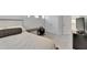 A minimalistic bedroom features light gray walls and carpet and a queen-sized bed at 28847 Orange Berry Dr, Wesley Chapel, FL 33543