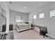 A minimalistic bedroom features light gray walls and carpet and a queen-sized bed at 28847 Orange Berry Dr, Wesley Chapel, FL 33543