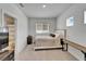 A minimalistic bedroom features light gray walls and carpet and a queen-sized bed at 28847 Orange Berry Dr, Wesley Chapel, FL 33543