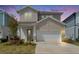 Charming two-story home illuminated at dusk, featuring a manicured lawn and a spacious two-car garage at 28847 Orange Berry Dr, Wesley Chapel, FL 33543