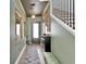 Elegant entryway featuring dark green walls, a staircase with black railings, and stylish decor accents at 28847 Orange Berry Dr, Wesley Chapel, FL 33543