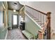 Elegant foyer with stylish decor, dark green accent wall and staircase with modern black railing at 28847 Orange Berry Dr, Wesley Chapel, FL 33543