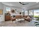 Beautiful living room features a large leather sectional and ample natural light at 28847 Orange Berry Dr, Wesley Chapel, FL 33543