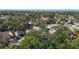 An aerial shot showing the neighborhood with mature trees and city skyline in the distance at 3020 E Louisiana Ave, Tampa, FL 33610
