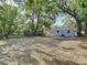Wide backyard with mature trees, fence, and gray-colored home exterior at 3020 E Louisiana Ave, Tampa, FL 33610