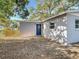 Exterior shows backyard with mature trees, new fence, and blue back door at 3020 E Louisiana Ave, Tampa, FL 33610