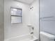 Updated bathroom showcases modern shower with textured tile and a combination tub and shower at 3020 E Louisiana Ave, Tampa, FL 33610