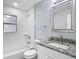 Bright bathroom with sleek white finishes, a granite vanity, and a modern tiled shower at 3020 E Louisiana Ave, Tampa, FL 33610