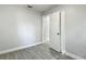 Bedroom featuring wood-look tile, a neutral paint scheme, and a closet and hallway entrance at 3020 E Louisiana Ave, Tampa, FL 33610