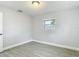 This bedroom features neutral paint, modern wood-look tile, and a window for natural light at 3020 E Louisiana Ave, Tampa, FL 33610