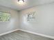 This bedroom has wood-look tile, neutral paint, and multiple windows for plenty of light at 3020 E Louisiana Ave, Tampa, FL 33610