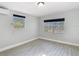 Bright bedroom with gray wood-look tile and natural light from multiple windows at 3020 E Louisiana Ave, Tampa, FL 33610