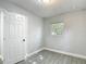 This bedroom features wood-look tile flooring, neutral paint, and a window providing natural light at 3020 E Louisiana Ave, Tampa, FL 33610