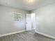 Bedroom featuring wood-look tile flooring, neutral paint, and a window offering natural light at 3020 E Louisiana Ave, Tampa, FL 33610