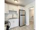Bright kitchen featuring white cabinets, stainless steel refrigerator and modern backsplash at 3020 E Louisiana Ave, Tampa, FL 33610