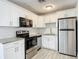 Well-lit kitchen featuring granite countertops, white cabinets and stainless steel appliances at 3020 E Louisiana Ave, Tampa, FL 33610