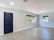 Bright, spacious living room with large windows and grey wood-look floors at 3020 E Louisiana Ave, Tampa, FL 33610