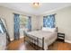 A cozy bedroom features hardwood flooring, a queen bed, and unique window coverings at 3510 4Th N Ave, St Petersburg, FL 33713