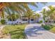 Landscaped front yard with a circular paver driveway, lush lawn, and palm trees at 368 41St Ave, St Pete Beach, FL 33706