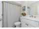 Bright bathroom with a white vanity, framed art and decorative woven fan at 375 Madeira Cir, St Petersburg, FL 33715