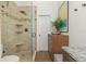 Modern bathroom features a glass shower with tiled walls, built-in shelves, and sleek, dark hardware fixtures at 375 Madeira Cir, St Petersburg, FL 33715