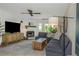 Cozy living room with a brick fireplace, ceiling fan, and stylish decor at 375 Madeira Cir, St Petersburg, FL 33715