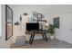 Modern home office with gallery wall, stylish desk, and comfortable ottoman at 375 Madeira Cir, St Petersburg, FL 33715
