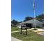 Community clubhouse featuring a well-manicured lawn, clear blue skies, and an American flag waving in the wind at 3803 N Oak Dr # B21, Tampa, FL 33611