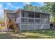 A charming screened-in back porch with white lattice and backyard access, perfect for outdoor relaxation at 403 Saint Petersburg W Dr, Oldsmar, FL 34677