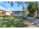 Exterior view of backyard with green space, trees, and covered back porch at 403 Saint Petersburg W Dr, Oldsmar, FL 34677