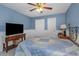 Bedroom with wood ceiling fan, wainscoting, and neutral bedding at 403 Saint Petersburg W Dr, Oldsmar, FL 34677