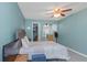 Cozy bedroom with light blue walls, a ceiling fan, and an organized walk-in closet for ample storage at 403 Saint Petersburg W Dr, Oldsmar, FL 34677