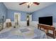 Primary bedroom with attached bath, furniture, television, and wood ceiling fan at 403 Saint Petersburg W Dr, Oldsmar, FL 34677