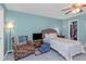 Cozy bedroom with light blue walls, a ceiling fan, and an organized walk-in closet for ample storage at 403 Saint Petersburg W Dr, Oldsmar, FL 34677