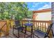Outdoor wooden deck area featuring chairs, a small table, and views of the surrounding trees at 403 Saint Petersburg W Dr, Oldsmar, FL 34677