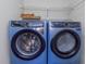 Modern laundry room with blue Electrolux washer and dryer, and wire shelving at 403 Saint Petersburg W Dr, Oldsmar, FL 34677